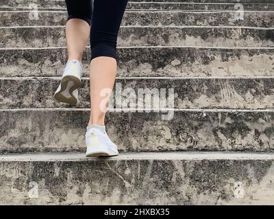 Die Läuferin geht die Treppe hoch und macht Cardio-Sport-Workout. Stockfoto