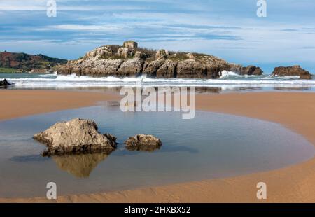 Die Insel San Pedruco oder San Pedro liegt am Strand von RIS in Noja, Kantabrien, Spanien Stockfoto