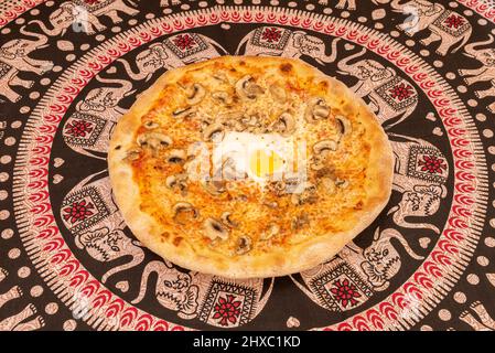 Einige Versionen dieser italienischen Funghi-Pizza verwenden Schweinefleisch, wie geschredderte Wurst, gekochten Schinken oder geräucherten Speck Stockfoto