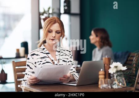 Alles sieht in Ordnung aus. Eine kurze Aufnahme einer attraktiven Frau mittleren Alters, die während des Tages Schreibarbeiten machte, während sie in einem Café saß. Stockfoto