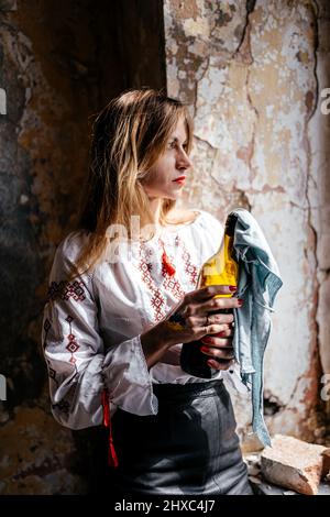 Molotow-Cocktail in den Händen einer ukrainischen Frau in Stickerei Stockfoto