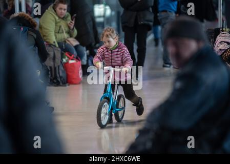 Warschau, Polen. 11. März 2022. 11. März 2022: Ein ukrainisches Flüchtlingsmädchen spielt am Bahnhof mit einem Fahrrad. Am Bahnhof wurde ein Hilfszentrum für Flüchtlingskinder eingerichtet (Bild: © Hector Adolfo Quintanar Perez/ZUMA Press Wire) Quelle: ZUMA Press, Inc./Alamy Live News Stockfoto