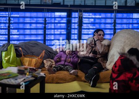 Warschau, Polen. 11. März 2022. 11. März 2022: Ein Mädchen und ihre Mutter, die vor dem Krieg in der Ukraine fliehen, ruhen in den Einrichtungen des Warschauer Bahnhofs. (Bild: © Hector Adolfo Quintanar Perez/ZUMA Press Wire) Bild: ZUMA Press, Inc./Alamy Live News Stockfoto