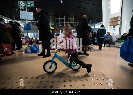 Warschau, Polen. 11. März 2022. 11. März 2022: Ein ukrainisches Flüchtlingsmädchen spielt am Bahnhof mit einem Fahrrad. Am Bahnhof wurde ein Hilfszentrum für Flüchtlingskinder eingerichtet (Bild: © Hector Adolfo Quintanar Perez/ZUMA Press Wire) Quelle: ZUMA Press, Inc./Alamy Live News Stockfoto