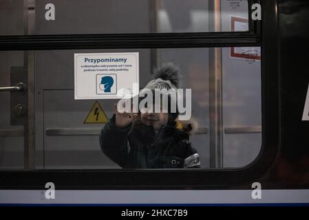 Warschau, Polen. 11. März 2022. 11. März 2022: Ein Junge winkt Auf Wiedersehen an, als er in den Zug fährt, der ukrainische Flüchtlinge nach Polen bringt, um dem Krieg zu entkommen. (Bild: © Hector Adolfo Quintanar Perez/ZUMA Press Wire) Bild: ZUMA Press, Inc./Alamy Live News Stockfoto