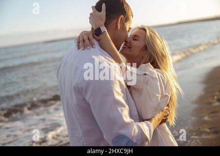 Porträt eines sorglosen Paares, das sich am Strand küsst Stockfoto