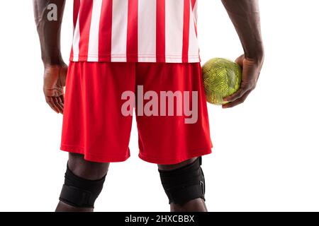 Mittelteil des afroamerikanischen männlichen Handballspielers mit grüner Kugel auf weißem Hintergrund Stockfoto