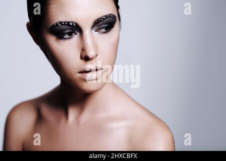 Shes hat eine kantige Schönheit. Studioaufnahme einer schönen jungen Frau mit metallisch-farbenem Make-up. Stockfoto