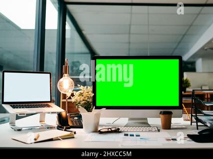 Bereit, dieses Geschäft online zu bringen. Aufnahme eines Desktop-Computers mit einem grünen Bildschirm auf einem Tisch im Büro während des Tages. Stockfoto