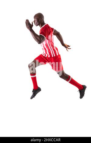 In voller Länge Seitenansicht des jungen afroamerikanischen Fußballspielers, der auf weißem Hintergrund läuft Stockfoto