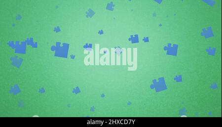 Bild von blauen Puzzleteilen, die auf grünen Hintergrund fallen Stockfoto