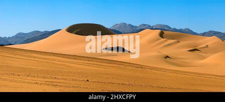 Sanddünen und felsige Berge in der Wüste der Nordsahara Stockfoto