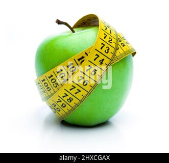 Grüner Apfel mit Maßband isoliert auf weißem Hintergrund Stockfoto