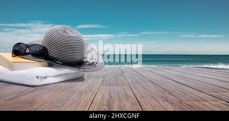 Badeutensilien auf einer Holzterrasse am Meer Stockfoto