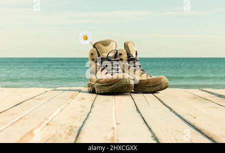 Wanderschuhe auf einer Terrasse am Meer Stockfoto