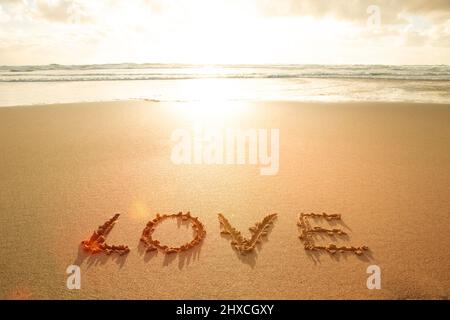 Das Wort Liebe in den Sand geschrieben Stockfoto