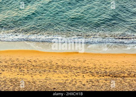 Sandstrand mit Welle an der Wasserlinie Stockfoto