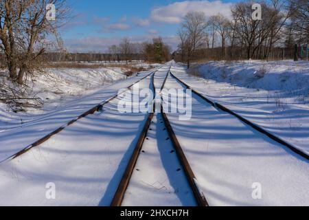 Alte ungenutzte verschneite Bahngleise im Winter in Deutschland Stockfoto