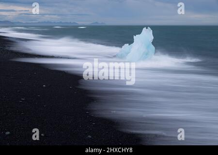 Eis und Wellen am Black Beach in der Nähe der Gletscherlagune Jökulsárlón, Vatnajokull-Nationalpark, Island Stockfoto