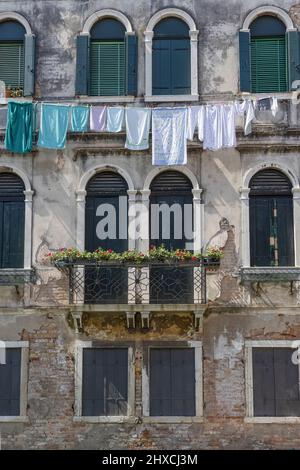 Alte venezianische Hausfassade mit straffer Wäscheleine in Venedig, Italien Stockfoto