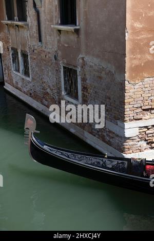 Bug einer venezianischen Gondel, die einen Kanal in Venedig, Italien, hinunterfährt Stockfoto