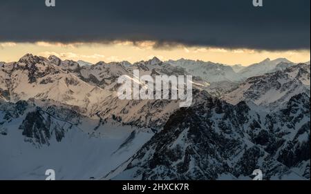 Alpine Berglandschaft im Winter. Sonnenlicht bricht durch Wolken. Blick vom Großen Daumen. Allgäuer Alpen. Bayern, Deutschland, Europa Stockfoto