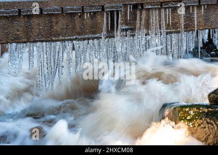 Eiszapfen und schnell fließender Bach, Torup, Halland, Schweden Stockfoto