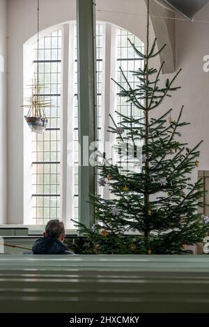 Seemannskirche Prerow, Mann, der vor dem Weihnachtsbaum sitzt Stockfoto