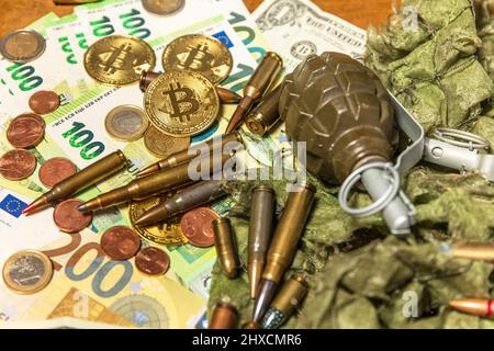 Unterstützung für die Ukraine. Krieg in der Ukraine. Euro-Münzen und -Banknoten und -Patronen verschiedener Kaliber. Verkauf von Waffen. Kriegsmunition Stockfoto