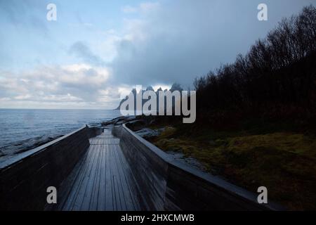 Herbstimpressionen von der norwegischen Insel Senja über dem Polarkreis, Skandinavien und Norwegen pur, Blick auf die Bergkette Okshornan oder Teufelszähne, Ersfjord, Holzsteg bei Tungeneset, Stockfoto