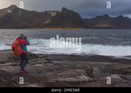 Herbsteindrücke von der norwegischen Insel Senja über dem Polarkreis, Skandinavien und Norwegen pur, Frau mit Rucksack beim Fotografieren, Stockfoto