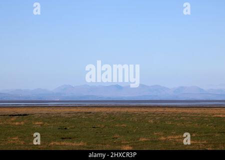 Fernsicht auf die Hügel des englischen Lake District von Pilling Lane Preesall aus, mit Blick auf Pilling Sands und die Mündung des Flusses Lune an einem klaren Tag. Stockfoto