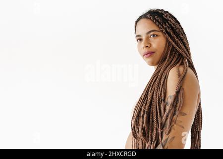 Lächelnde junge afrikanische Frau mit Dreadlocks über weißem Wandhintergrund Stockfoto