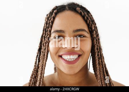 Lächelnde junge afrikanische Frau mit Dreadlocks über weißem Wandhintergrund und Blick auf die Kamera Stockfoto