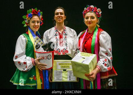 Excel London, Großbritannien. 11. März 2022. Die ukrainische Gruppe Prolisok Dance Ensemble spielt auf der Hauptbühne mit brüllendem Applaus des Publikums und beschaicke mit der von den Organisatoren unterstützten Charity Dance Aid Gelder für die Ukraine. Ivanna Rudnytska, Vicky Varodi und Roman posieren nach der Vorstellung in ihren traditionellen ukrainischen Kostümen. Nach zwei Jahren Abwesenheit ist eine der größten Tanz- und Performance-Shows und -Ausstellungen wieder in vollem Gange und Tausende von Besuchern und Performern besuchen dieses Wochenende die Ausgabe 15. im Excel London. Kredit: Imageplotter/Alamy Live Nachrichten Stockfoto