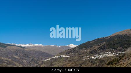 Ein Panoramablick auf das idyllisch weiß getünchte andalusische Bergdorf Capileira in der Sierra Nevada Stockfoto