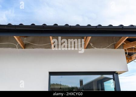 Dachbinder, durch die das Elektrokabel führt, um die Beleuchtung im Soffit zu verbinden. Stockfoto