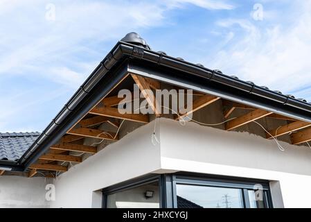 Dachbinder, durch die das Elektrokabel führt, um die Beleuchtung im Soffit zu verbinden. Stockfoto