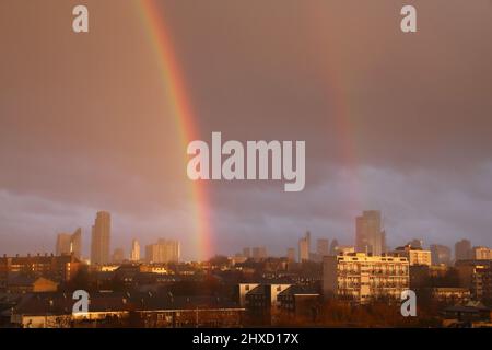 London, Großbritannien, 11.. März 2022. Unruhigen Wetterbedingungen führten zu einem atemberaubenden doppelten Regenbogen, der östlich der City of London liegt. Schwere Regenschauer und Sonneneinstrahlungen wurden prognostiziert. Kredit Monica Wells/Alamy Live Nachrichten Stockfoto