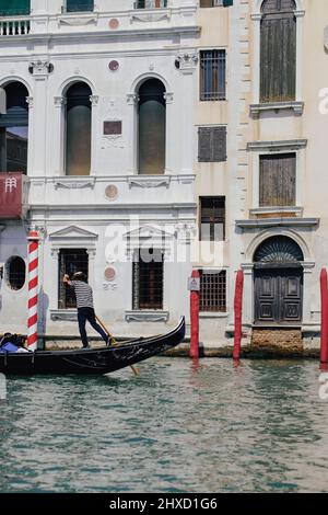 Venezianische Gondel vor einem renovierten Gebäude am Canale Grande in Venedig, Italien Stockfoto