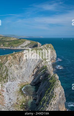 Eine Sommer-Tagesansicht von Lulworth Cove von den Hügeln über Stair Hole, die die verdrehten Felsformationen zeigt. Teil der Dorset Jurassic Küste. Stockfoto