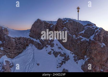 Morgenstimmung auf der Zugspitze, Sonnenaufgang auf Deutschlands höchstem Berg 'Top of Germany'. Landschaftsfotografie mit Zugspitzkreuz (4, 88 m) Stockfoto