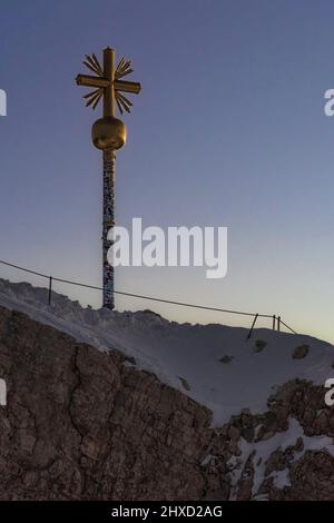 Morgenstimmung auf der Zugspitze, Sonnenaufgang auf Deutschlands höchstem Berg 'Top of Germany'. Landschaftsfotografie mit Zugspitzkreuz (4, 88 m) Stockfoto