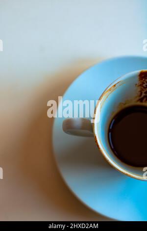 Türkischer Kaffee. Ich trank türkischen Kaffee mit dem Boden in der Tasse aus der Sicht von oben. Die Hälfte der Tasse. Selektiver Fokus auf den Vordergrund. Stockfoto