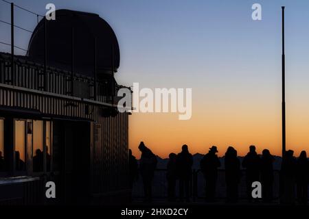 Morgenstimmung auf der Zugspitze, Sonnenaufgang auf Deutschlands höchstem Berg 'Top of Germany'. Frühaufsteher warten, bis sich die Sonne zeigt. Stockfoto