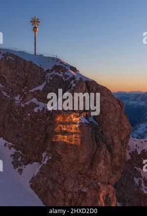 Morgenstimmung auf der Zugspitze, Sonnenaufgang auf Deutschlands höchstem Berg 'Top of Germany'. Landschaftsfotografie mit Zugspitzkreuz (4, 88 m) Stockfoto