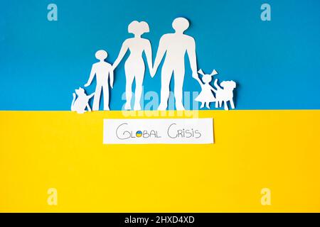Die globale Krise traf den Planeten 2022, mit russland gegen die ukraine. Papierschnitt einer Familie, die vor dem Elend flüchtete. Migration und Exodus. Stockfoto