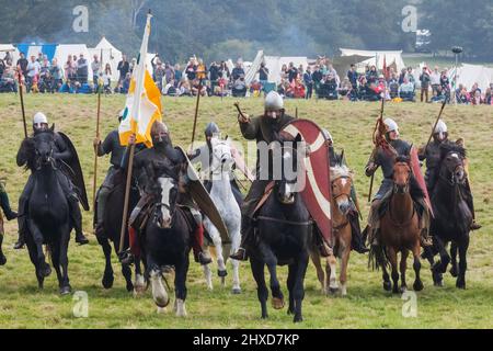 England, East Sussex, Battle, The Annual Battle of Hastings 1066 Re-enactment Festival, Teilnehmer gekleidet in mittelalterliche normannische Rüstungsaufladung auf dem Pferderücken Stockfoto