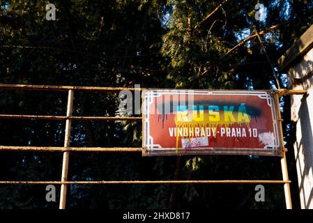 Rotes Straßenschild Ruska - Russisch - ist in Prag Vrsovice mit blauer und gelber Farbe als ukrainische Flagge übermalt Stockfoto