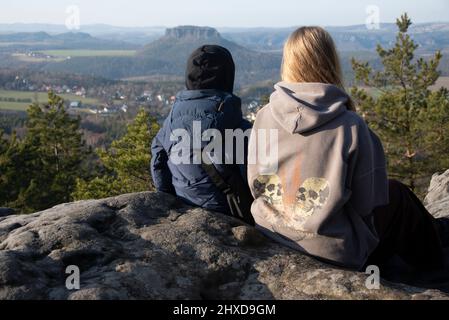 Zwei Kinder sitzen auf dem Papststein, dahinter der Lilienstein, Tafelberg im Elbsandsteingebirge, am Malerweg, Papstdorf, Sachsen, Deutschland Stockfoto